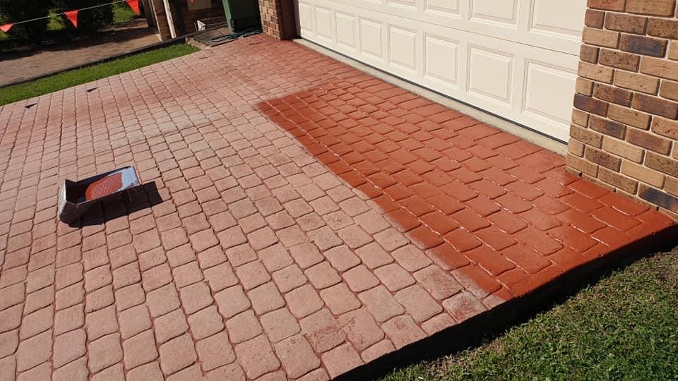 Paver driveway half stained, showing faded pavers beside freshly coated red pavers