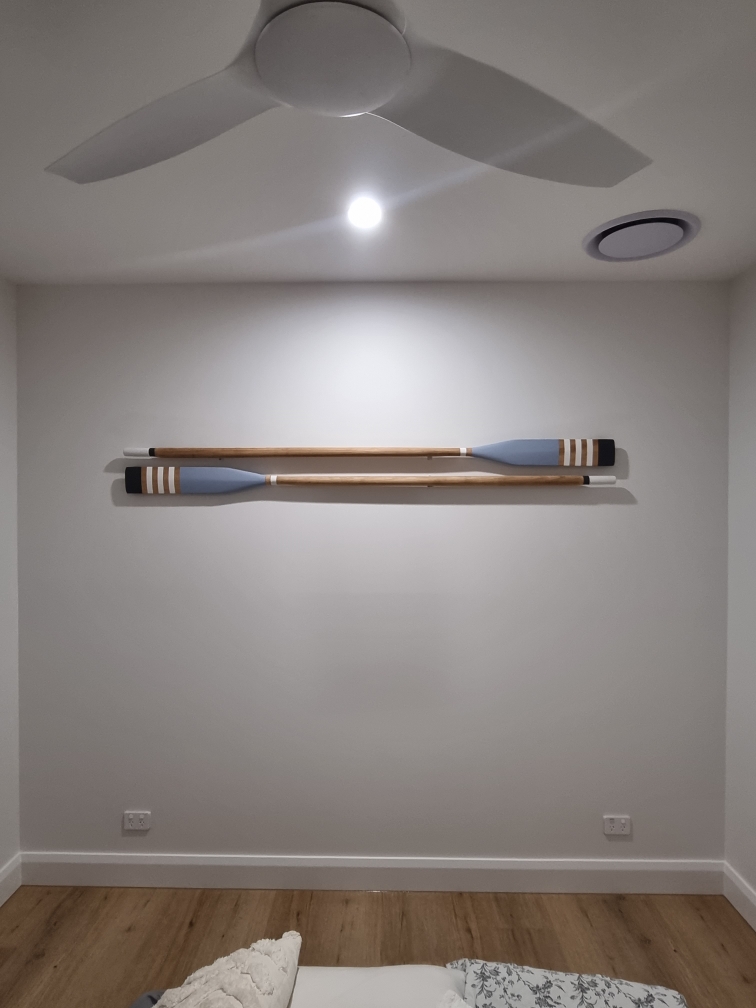 Freshly painted bedroom wall with decorative oars and a ceiling fan